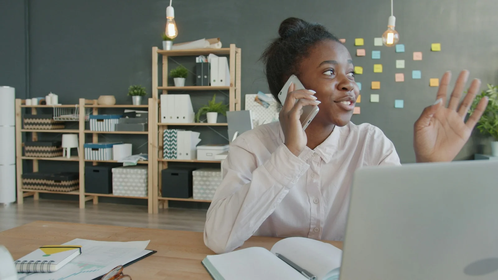 Profissional ao telefone com um cliente, em frente ao computador portátil
