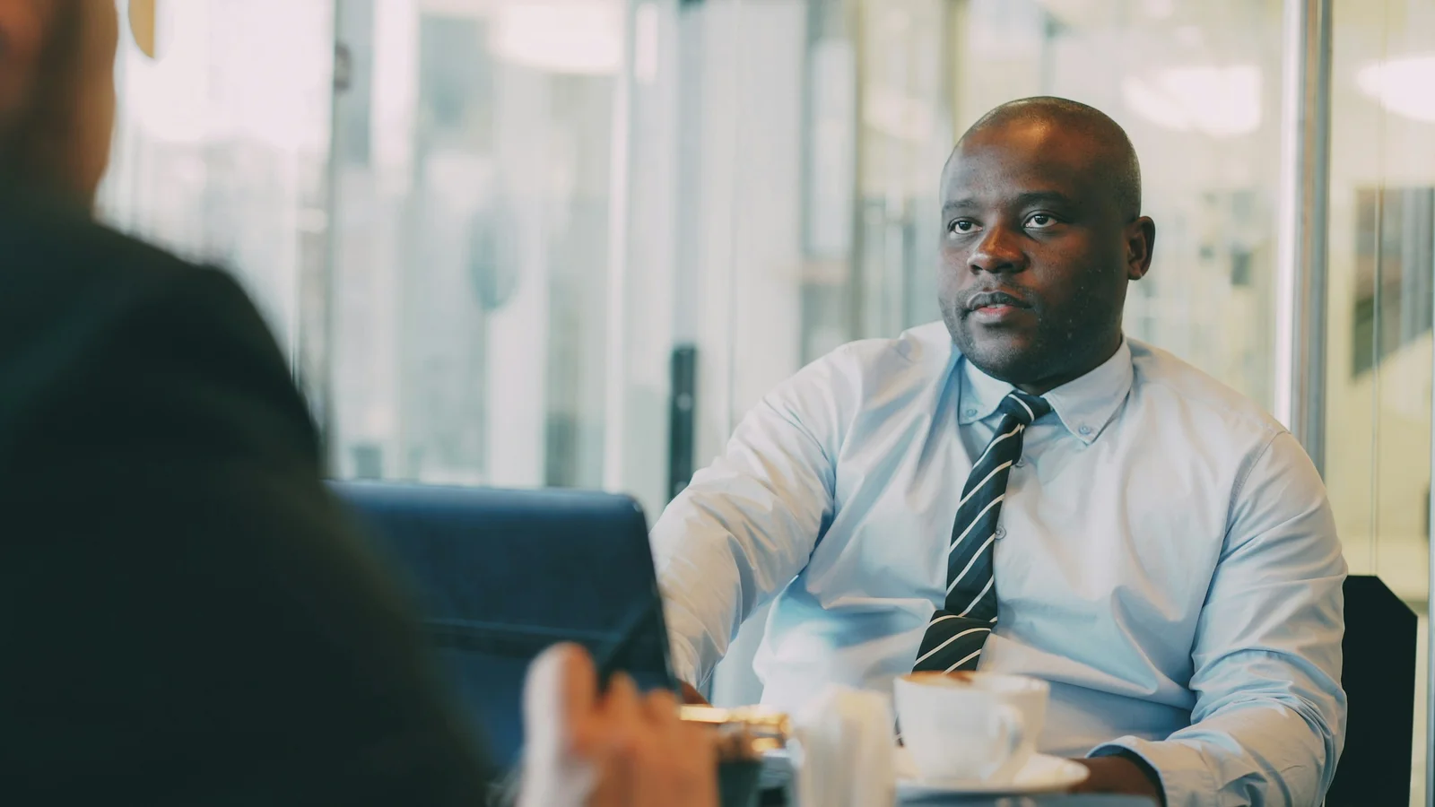 Advogado africano em conversa com um cliente no escritório